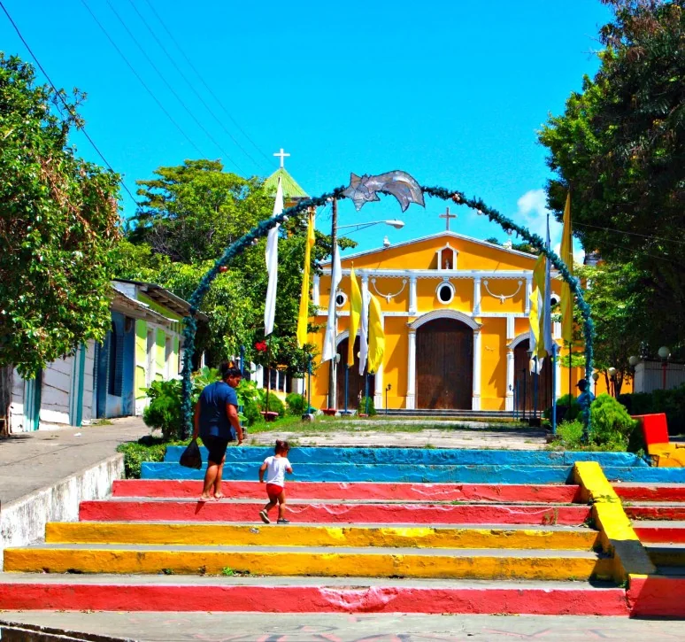 The parish church in Moyogalpa, with colorful steps and trees in front, photographed in 2016