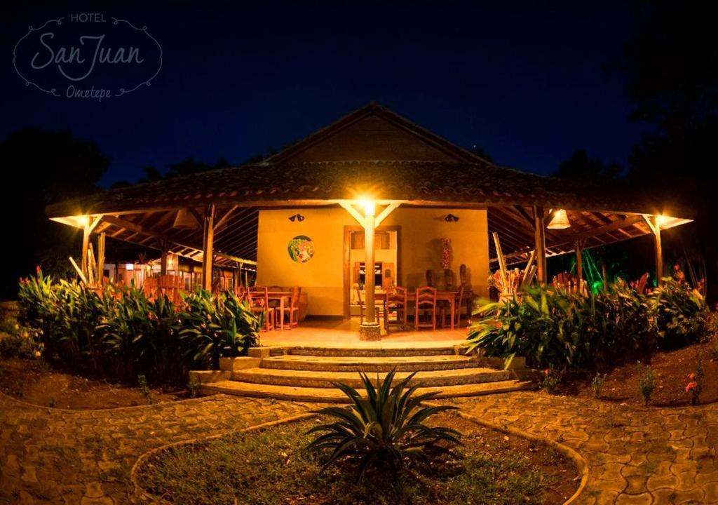 Illuminated entrance and garden at Hotel San Juan Ometepe after dark
